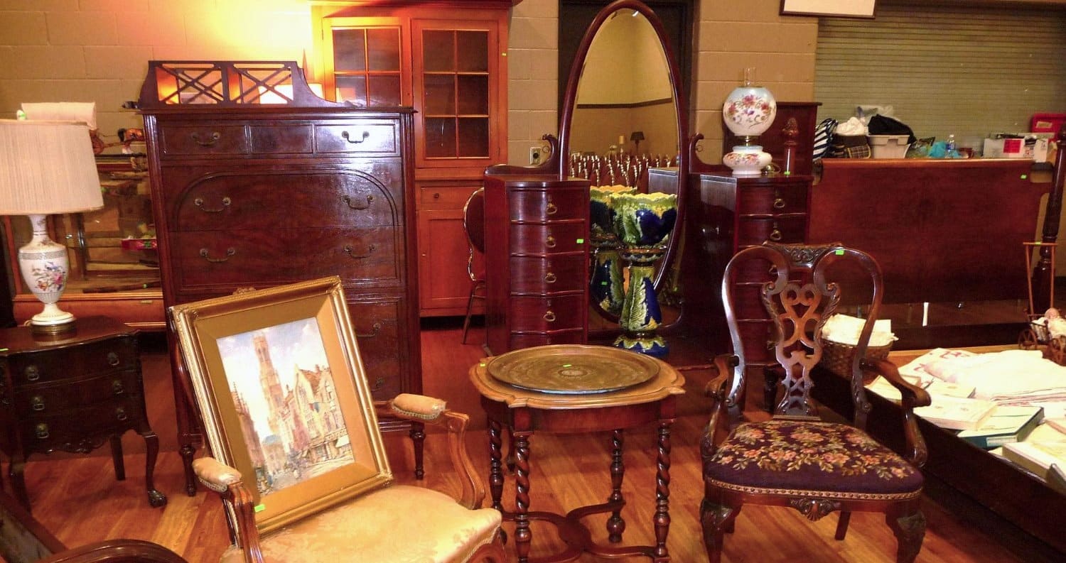 Antique furniture, a framed painting and decorative pieces in a furnished room